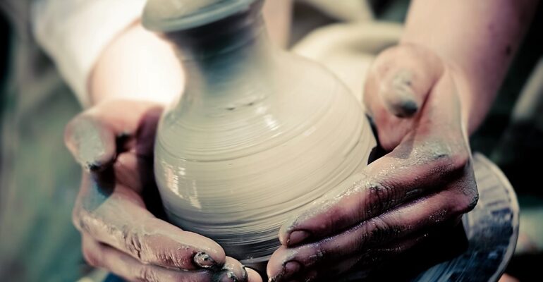 potter makes a jug out of clay